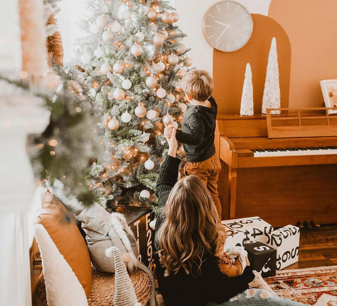 Artificial Christmas Tree being decorated by a little boy